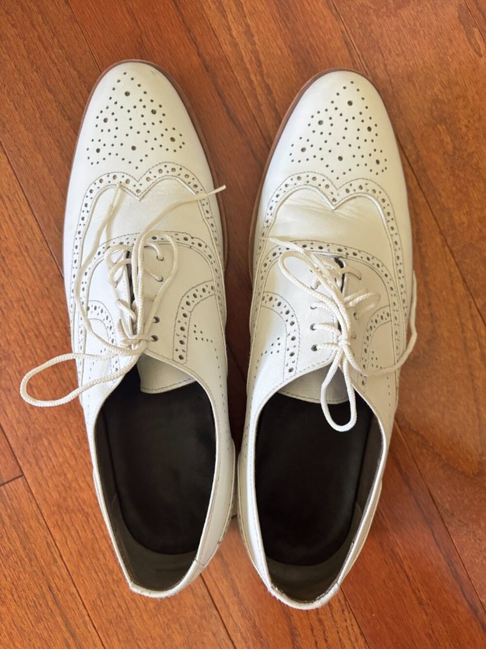 White leather wingtip shoes